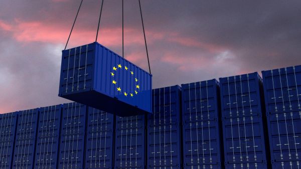 Crane lifting a shipping container marked with the EU flag