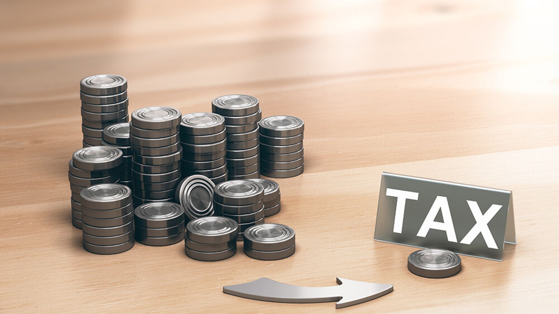 Coins in piles and arrow to word TAX