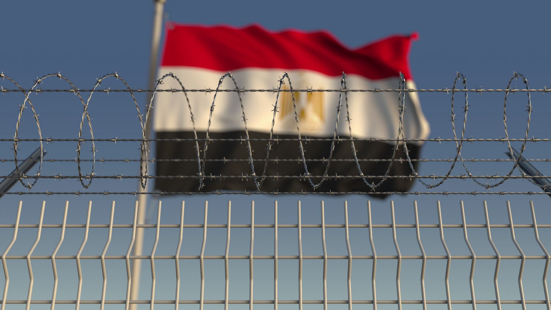 Egyptian flag flying behind a barbed wire fence