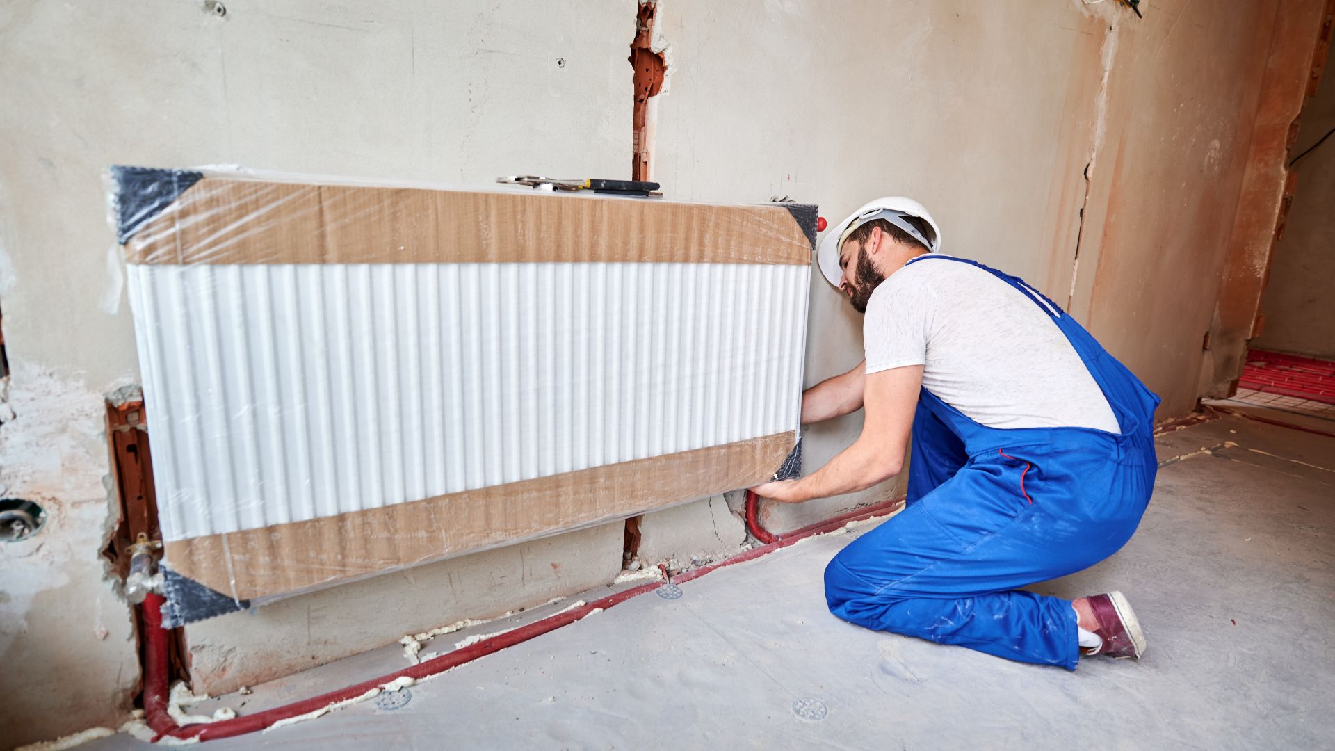 Workman installing new efficient radiators during a renovation