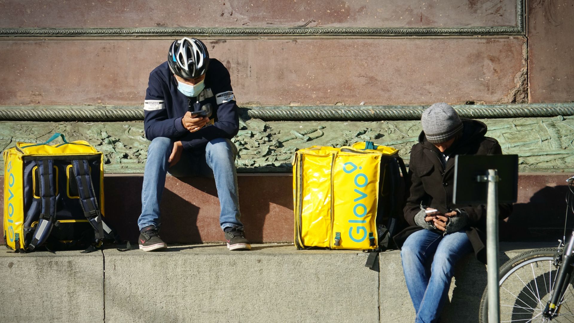 Gig economy delivery workers wait for work in Milan