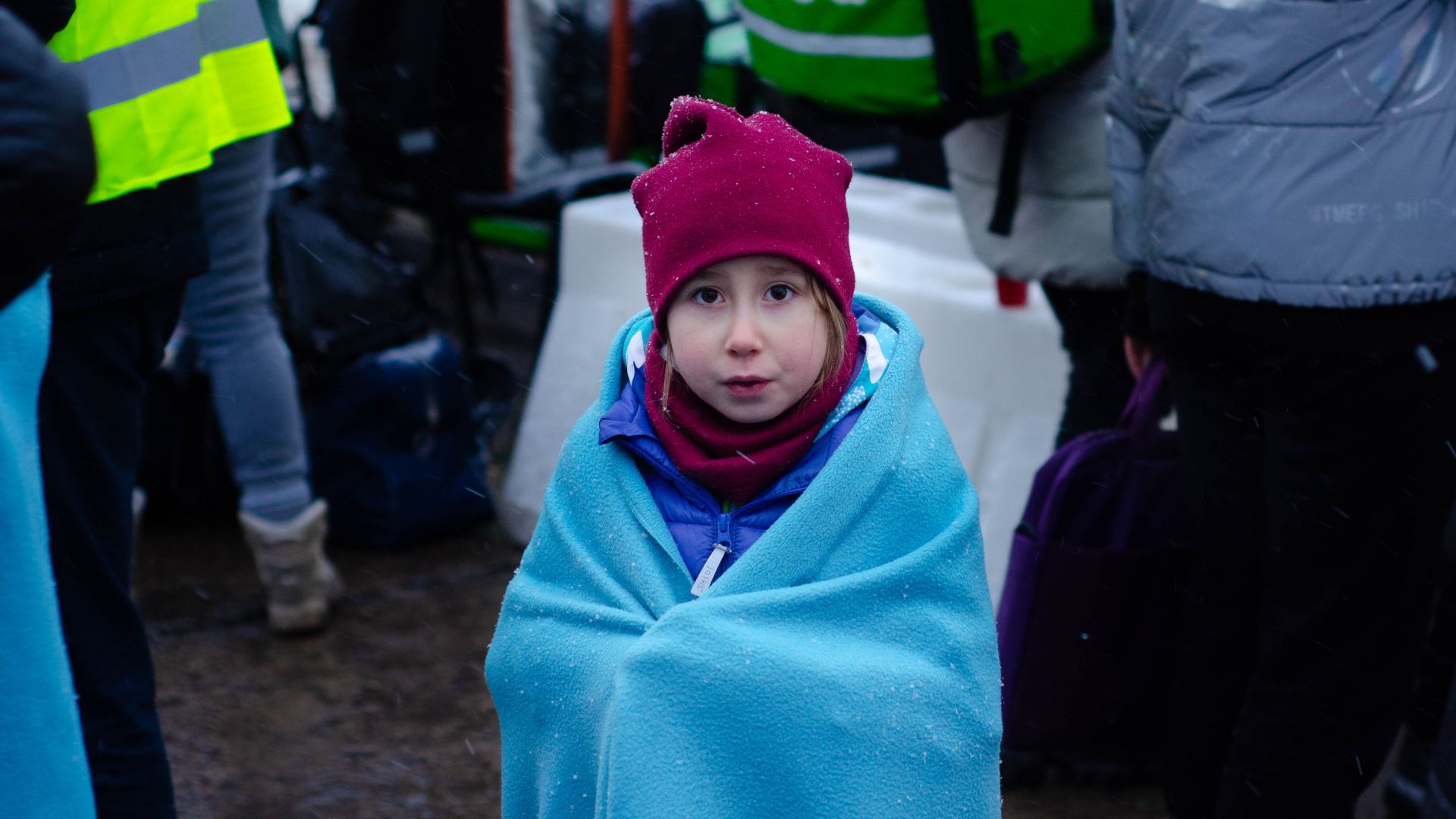 Ukrainian girl in a blanket fleeing the war at the Siret border in Romania 