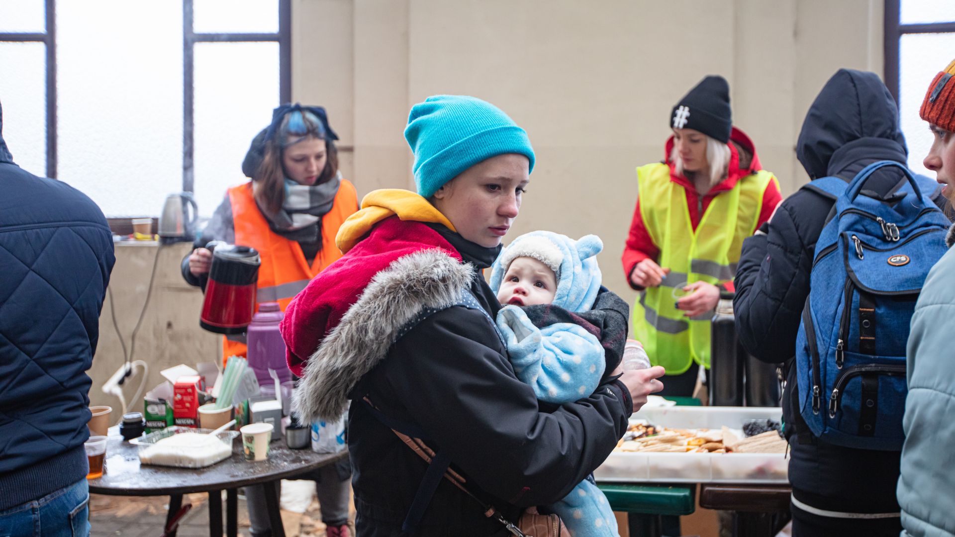 A woman and her baby among Ukrainian refugees on Lviv railway station waiting for train to escape to Europe