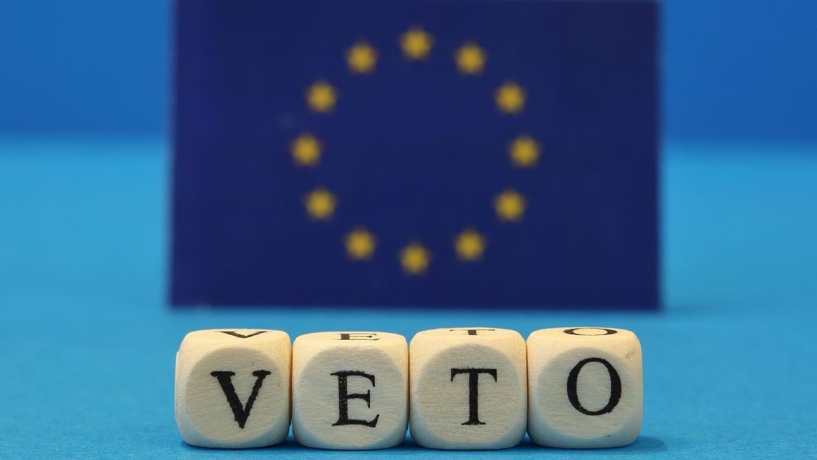 EU flag behind veto spelled with dice