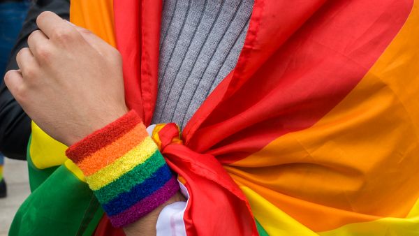 Protestor at a pro-LGBTI rally in Warsaw, Poland wrapped in a rainbow flag