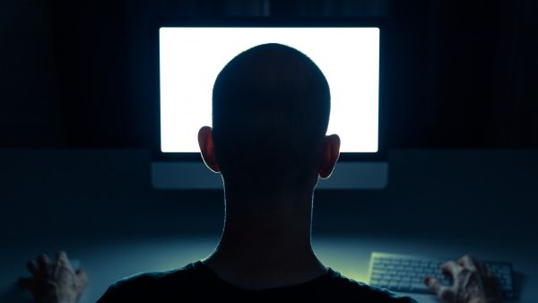Silhouette of a man using a computer