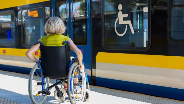 Woman with a wheelchair waiting to board a modern train