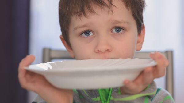 Boy holding empty plate 