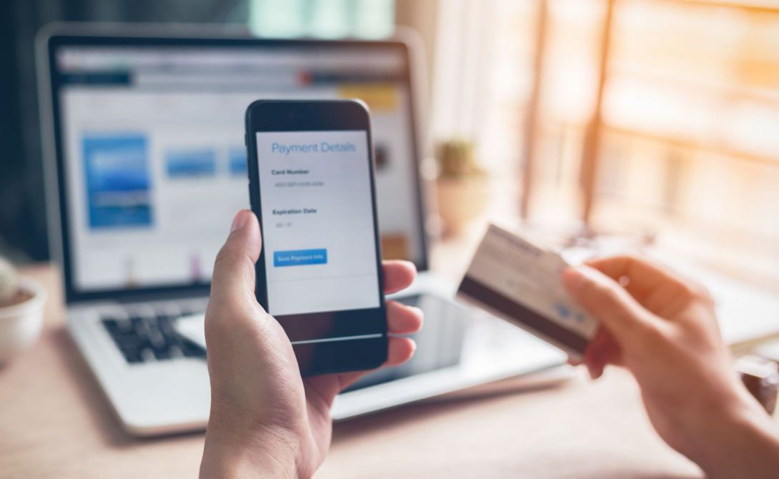 Image of person holding phone to purchase online
