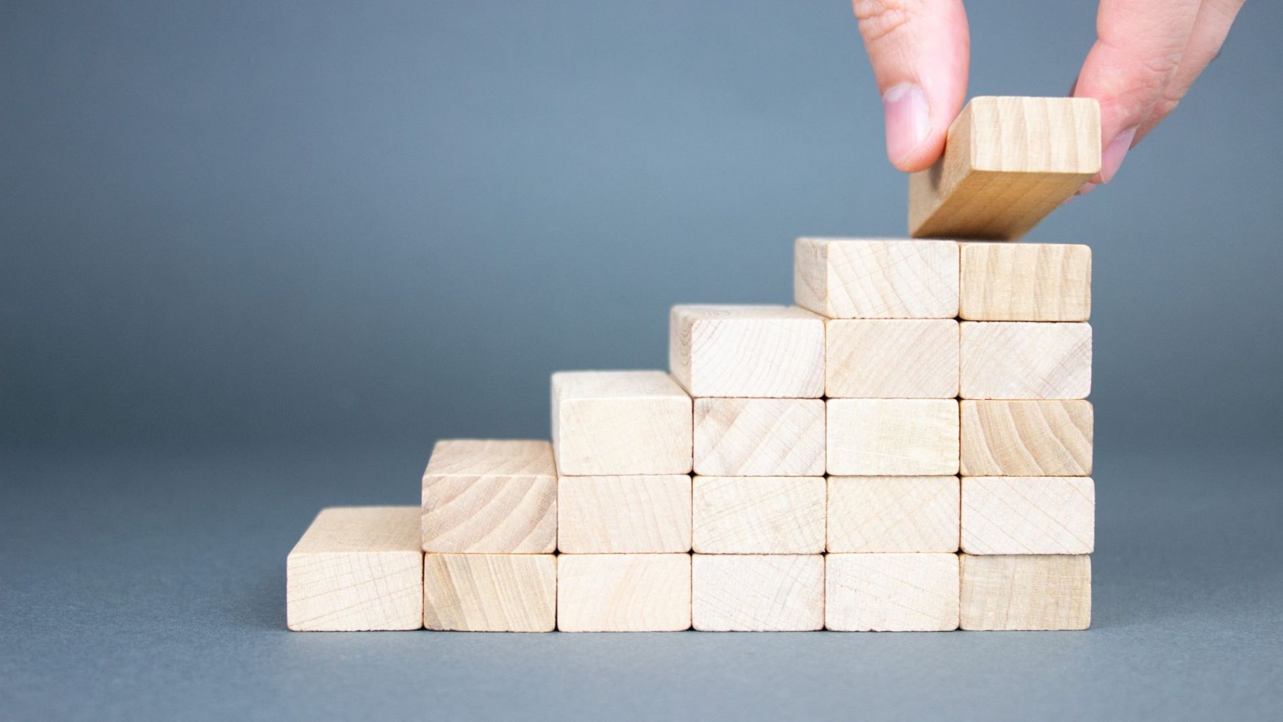 Image of hand laying down wooden steps
